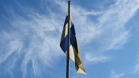 Suomenlippu sinistä taivasta vasten. Image Kristiina Pentikäinen