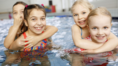 Neljä tyttöä AaltoAlvarin uima-altaassa toistensa reppuselässä. Kuva Hanna-Kaisa Hämäläinen