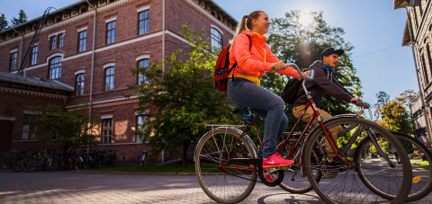 Opiskelijat pyöräilevät kampuksella. Kuva NitroID