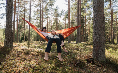 Isä ja tytär loikoilevat riippukeinussa. Kuva Kuvapankki: Shutterstock
