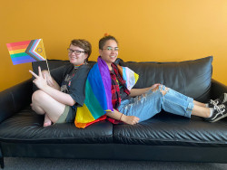 Kaksi nuorta sohvalla Nuorten talolla sateenkaarilippujen kanssa. Kuva Veera Rinta-Porkkunen