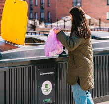 Nainen pudottamassa roskapussia roska-astiaan. Kuva MySome