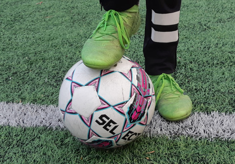 Jalka jalkapallon päällä tekonurmella. Image Jaana Pinson